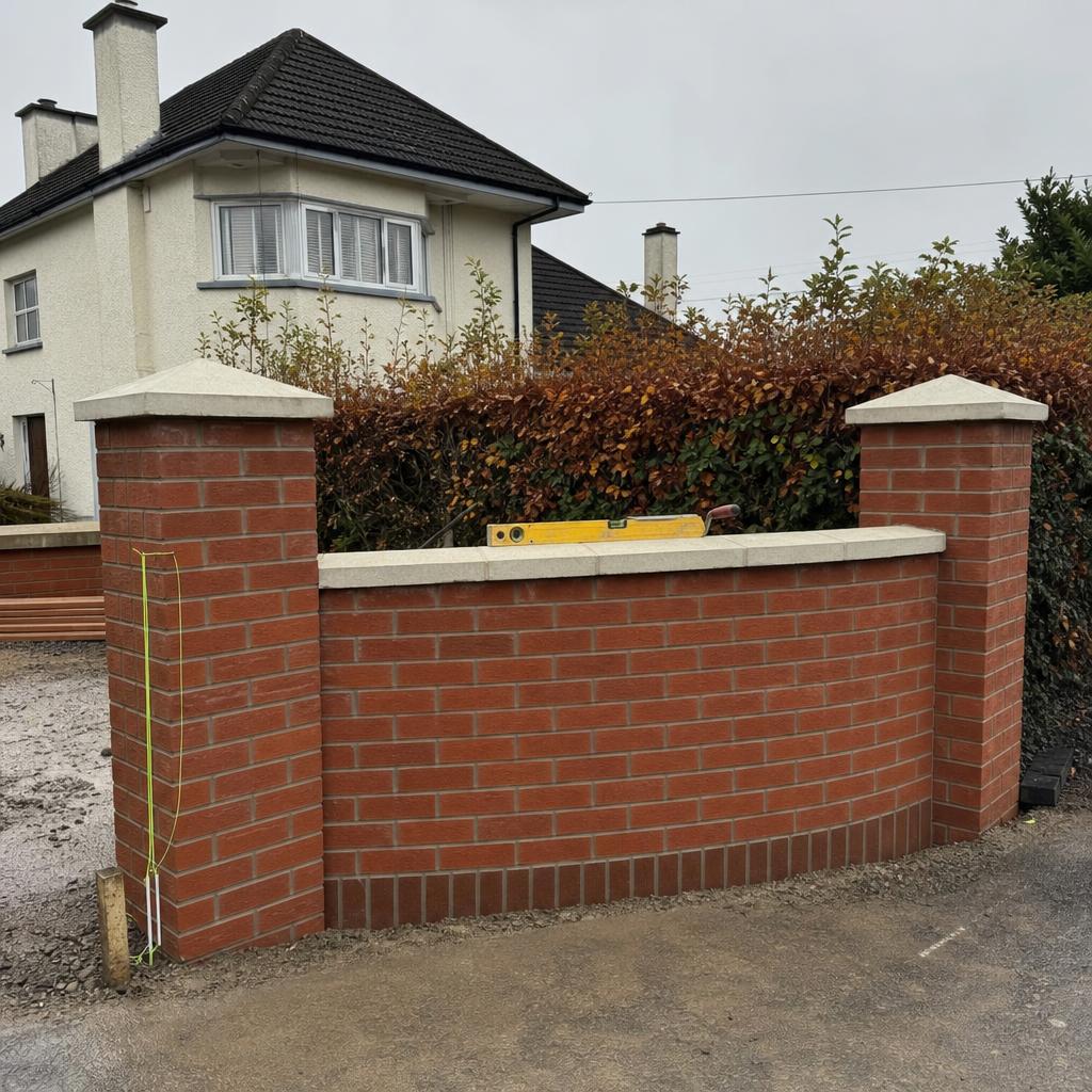 Curved red brick garden wall under construction in a Hillsborough garden