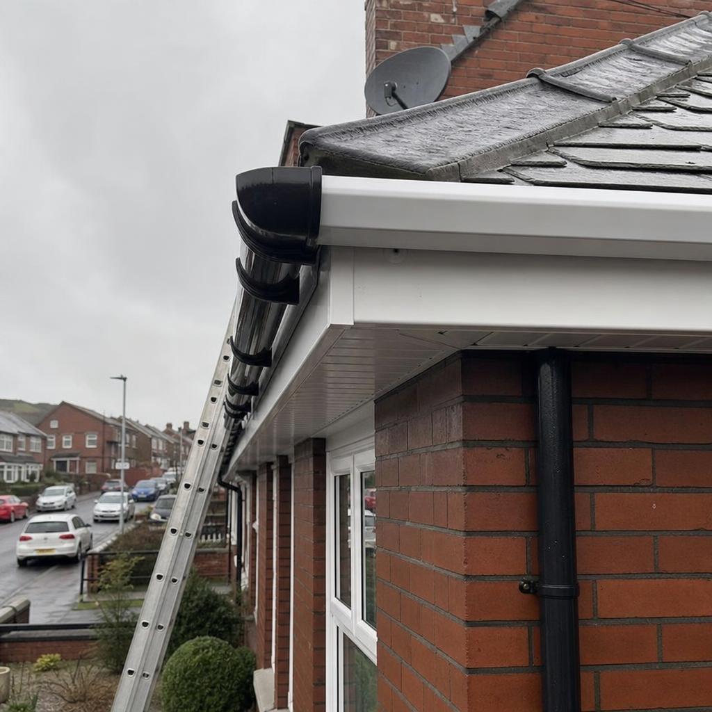 Tradesperson replacing UPVC gutter and fascia on a red-brick Belfast semi-detached home